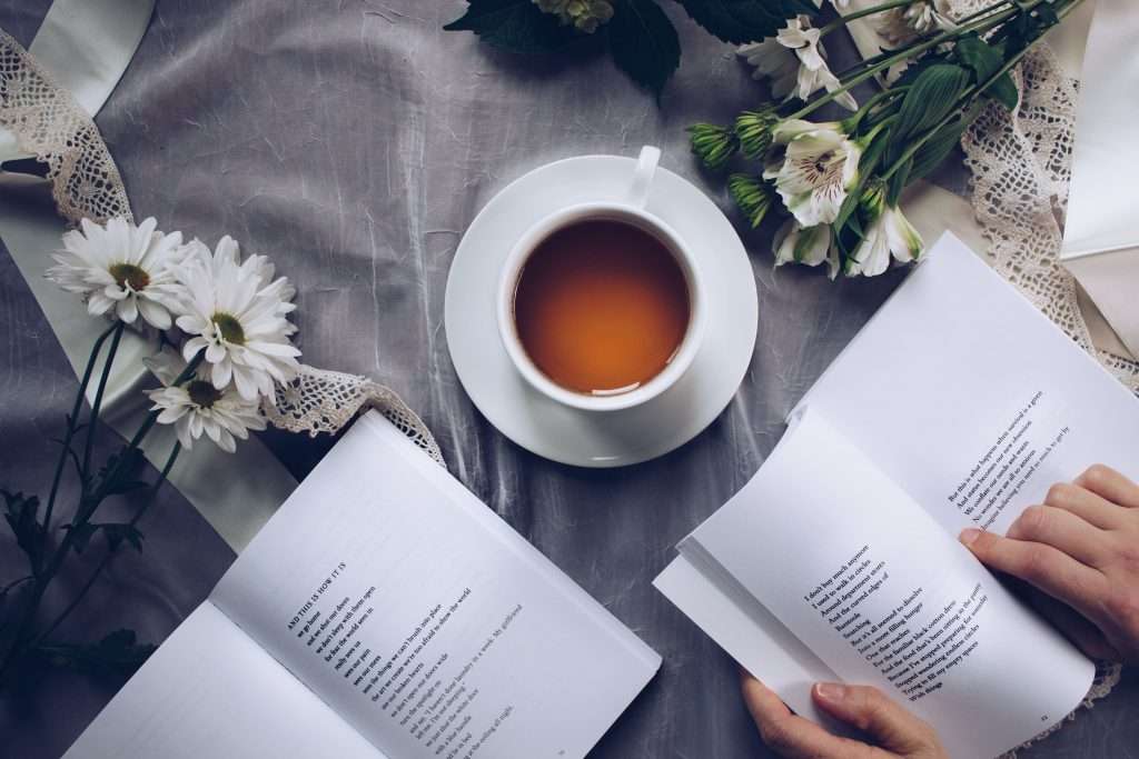 A cup of coffee and open poetry books