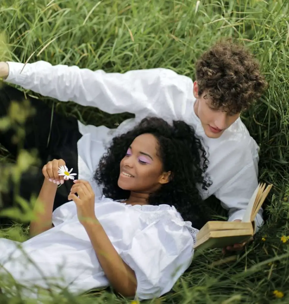 Cute couple reading intimate poems in the meadows