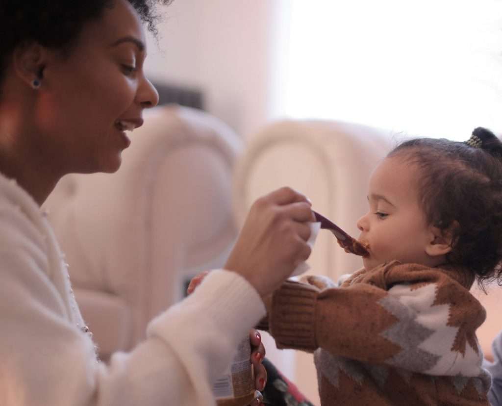 Mother feeding daughter