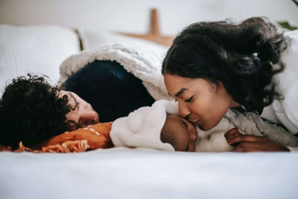 Mother kissing a sleeping baby girl