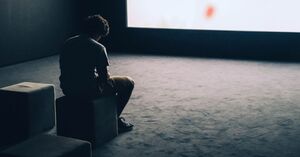 A depressed man seated alone in a room